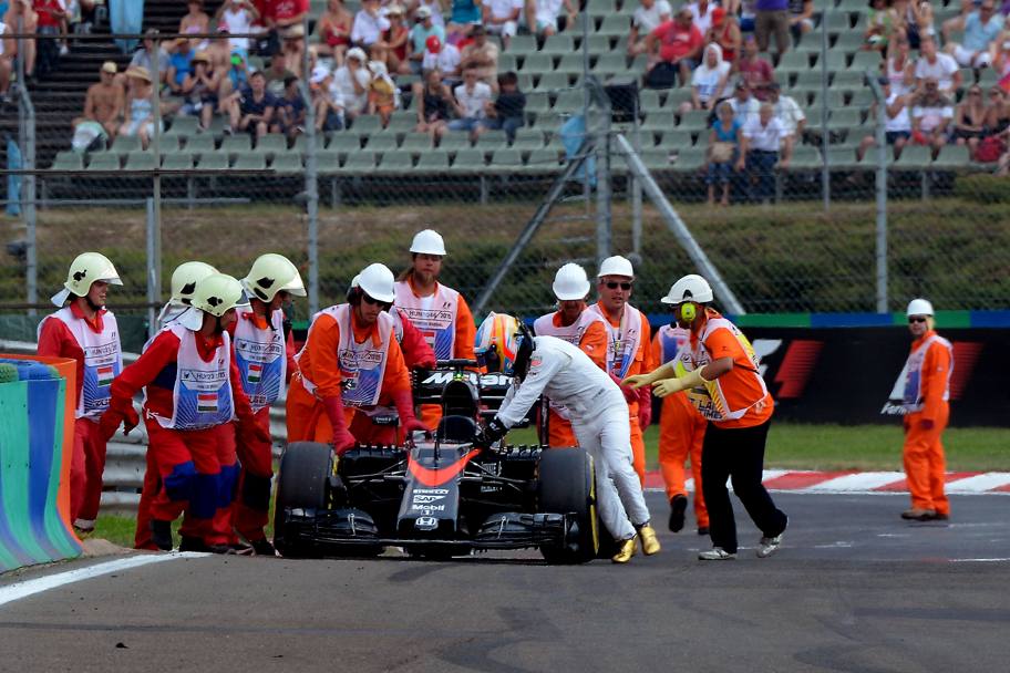 La McLaren di Fernando Alonso spinta dal pilota ai box per le riparazioni (Ercole Colombo)